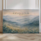 Decorative wall art with a mountain landscape and inspirational quote on a wooden floor.